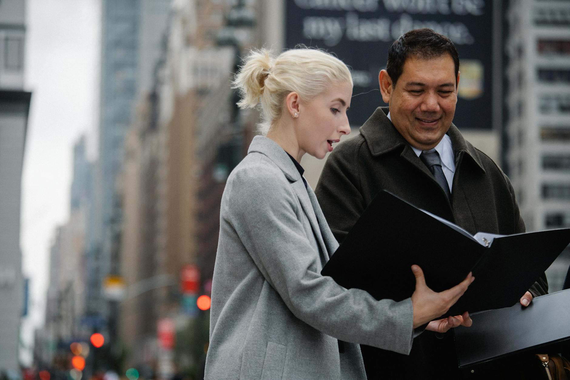 elegant multiethnic colleagues reading documents in city downtown